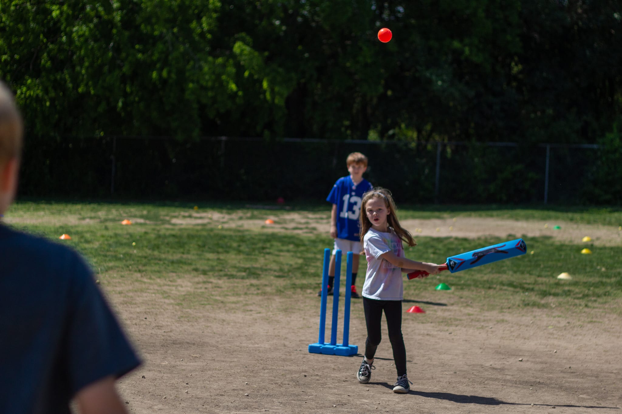 little girl batting cricket ball