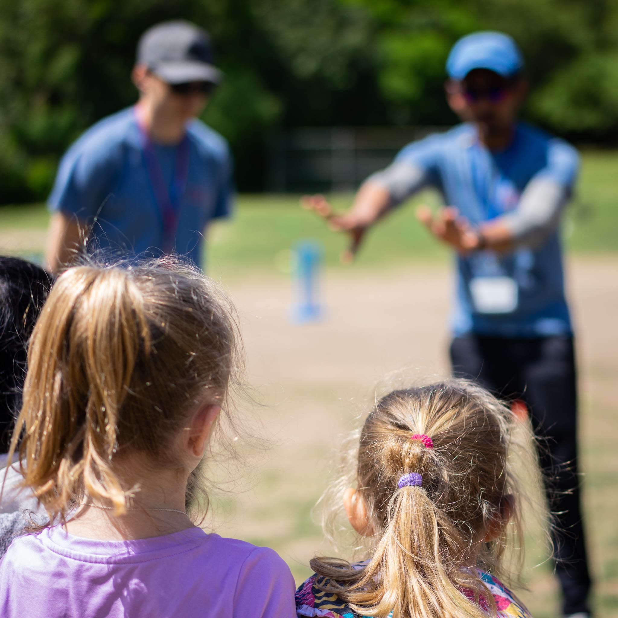 coaches blurred with two blonde girls in foreground