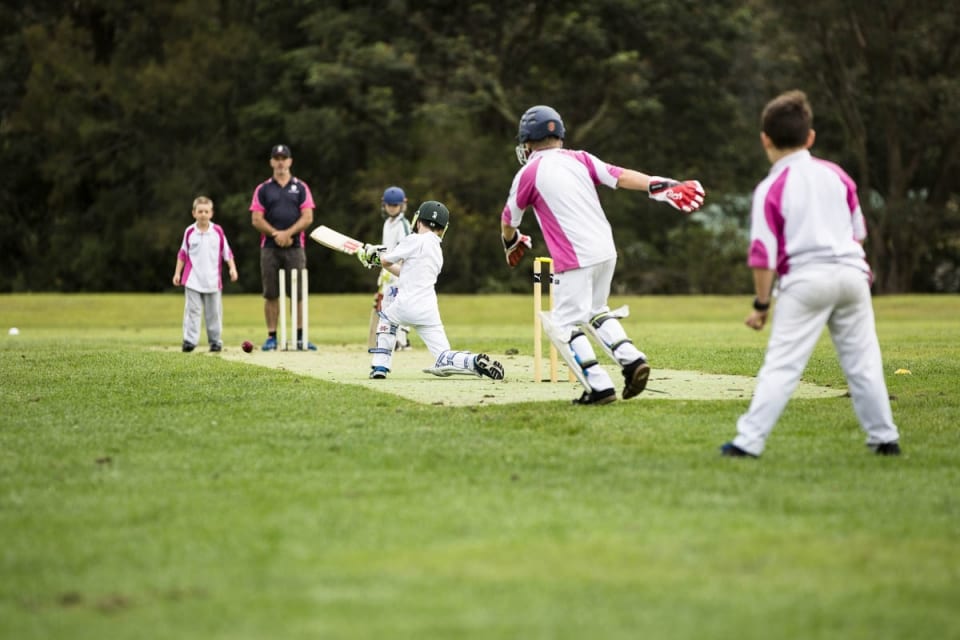 children playing cricket and batting