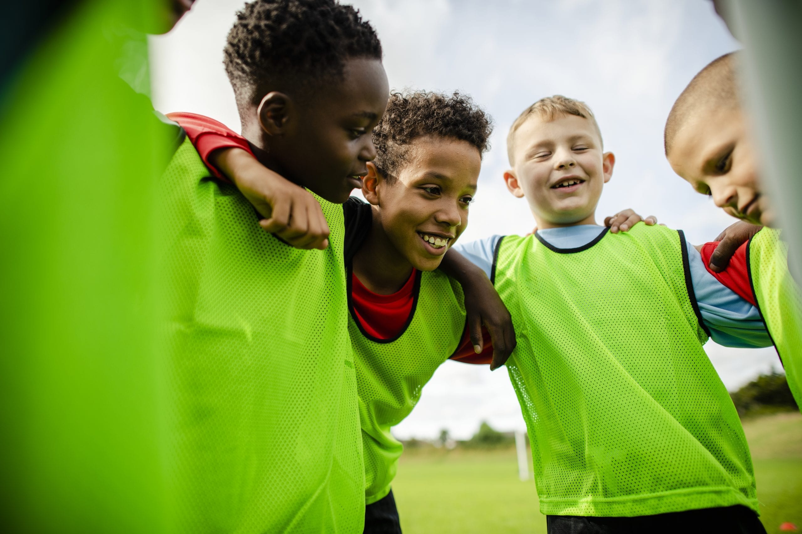 Junior soccer team huddling together